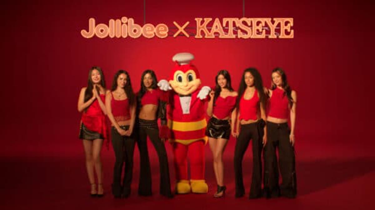 KATSEYE members posing with the Jollibee mascot